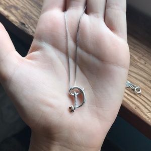 a sterling silver necklace with a “D” pendant